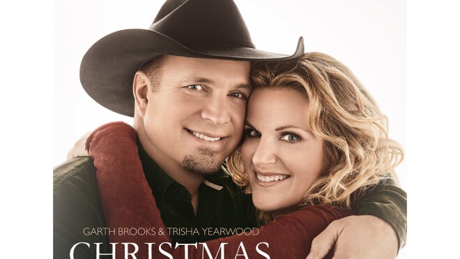 加斯·布鲁克斯和特丽莎·伊尔伍德面对镜头,微笑着拥抱在一起。加斯戴着一顶黑色牛仔帽,系着纽扣。特丽莎一头松散的卷发,穿着酒红色的长袖上衣。