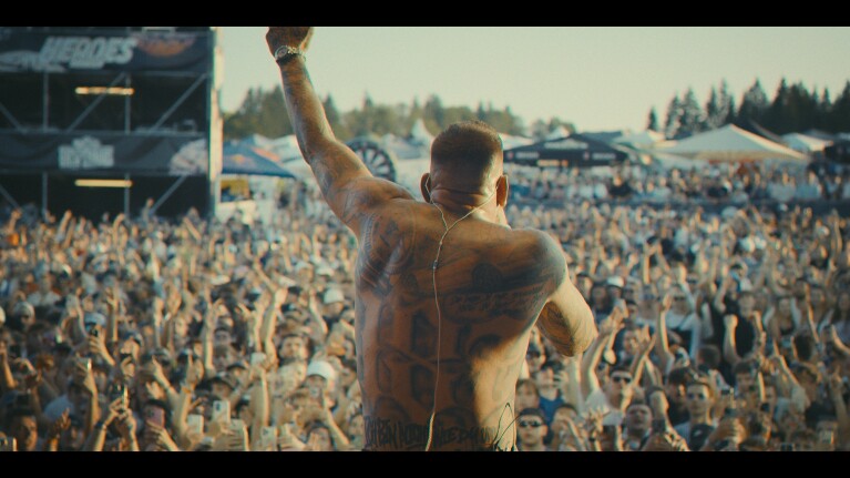 Hamburger Rapper GZUZ in der Dokumentation Licht_und_Schatten spielt auf einem Konzert vor einer großen Menschenmenge.
