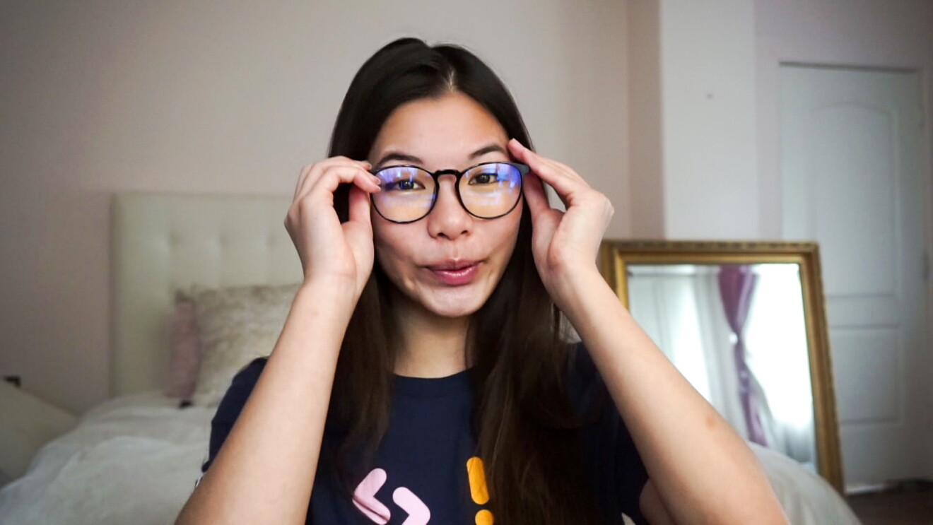 A young woman puts her glasses on 