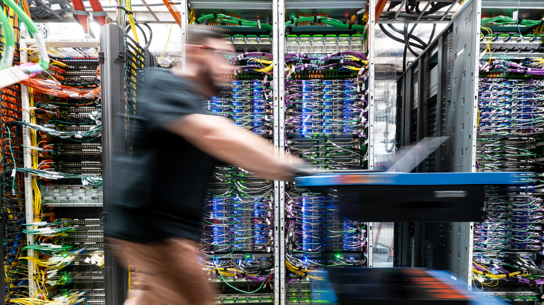 A man pushing cart within a data center.