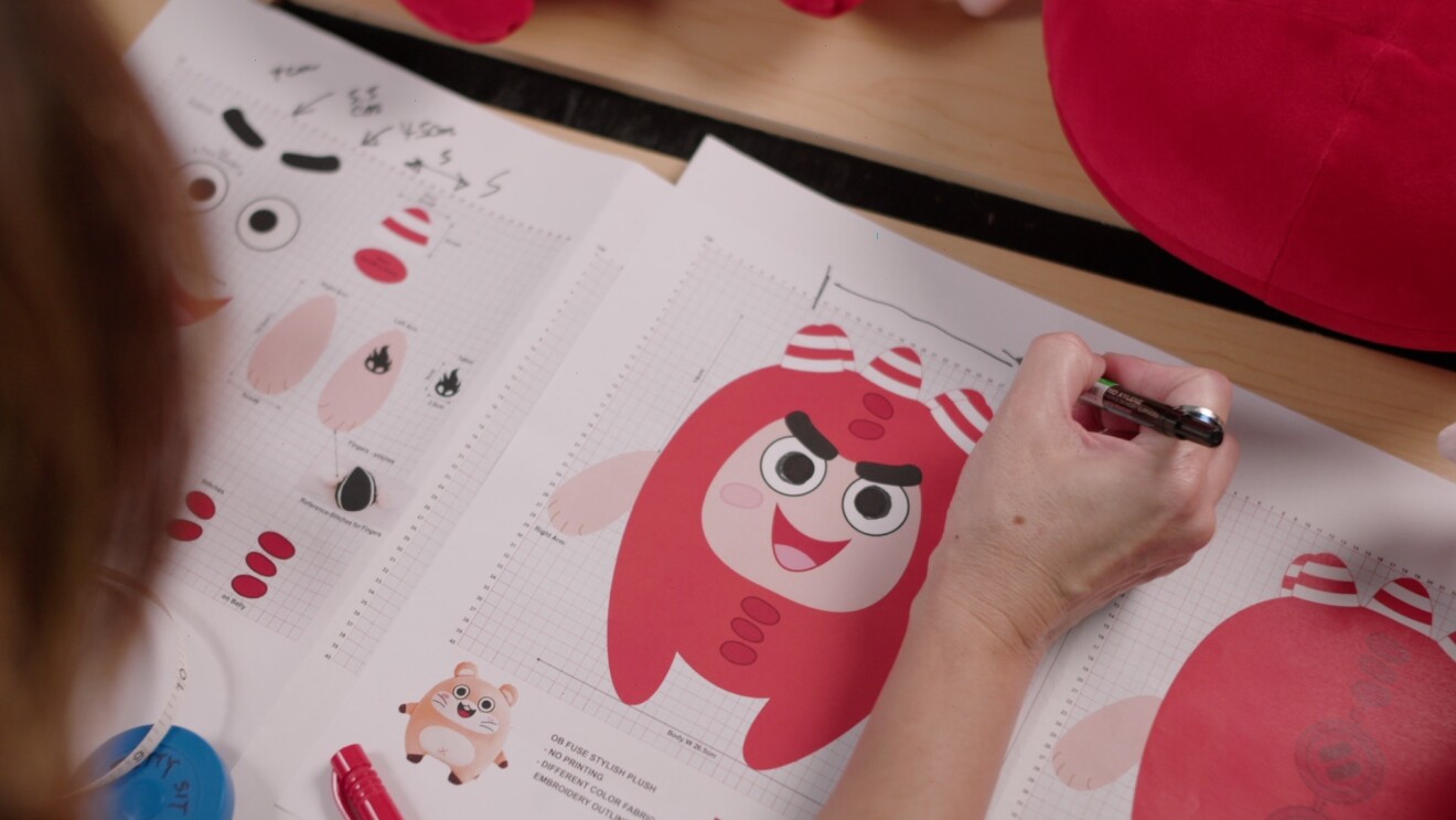 A lady checking the dimensions of an Oddbods plushie