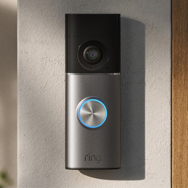 Ring video doorbell mounted on wall next to wooden door frame