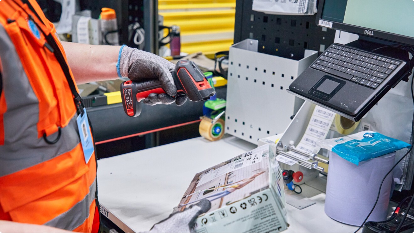 Amazon associate scanning shipping label on returned parcel