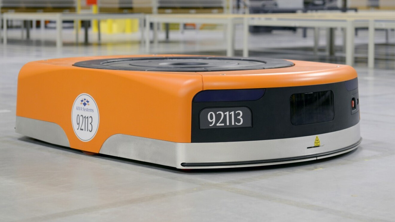 The image of an Amazon robot, in the shape of a thick disk moving on the ground. Its color is orange and black, the code number is 92113. 