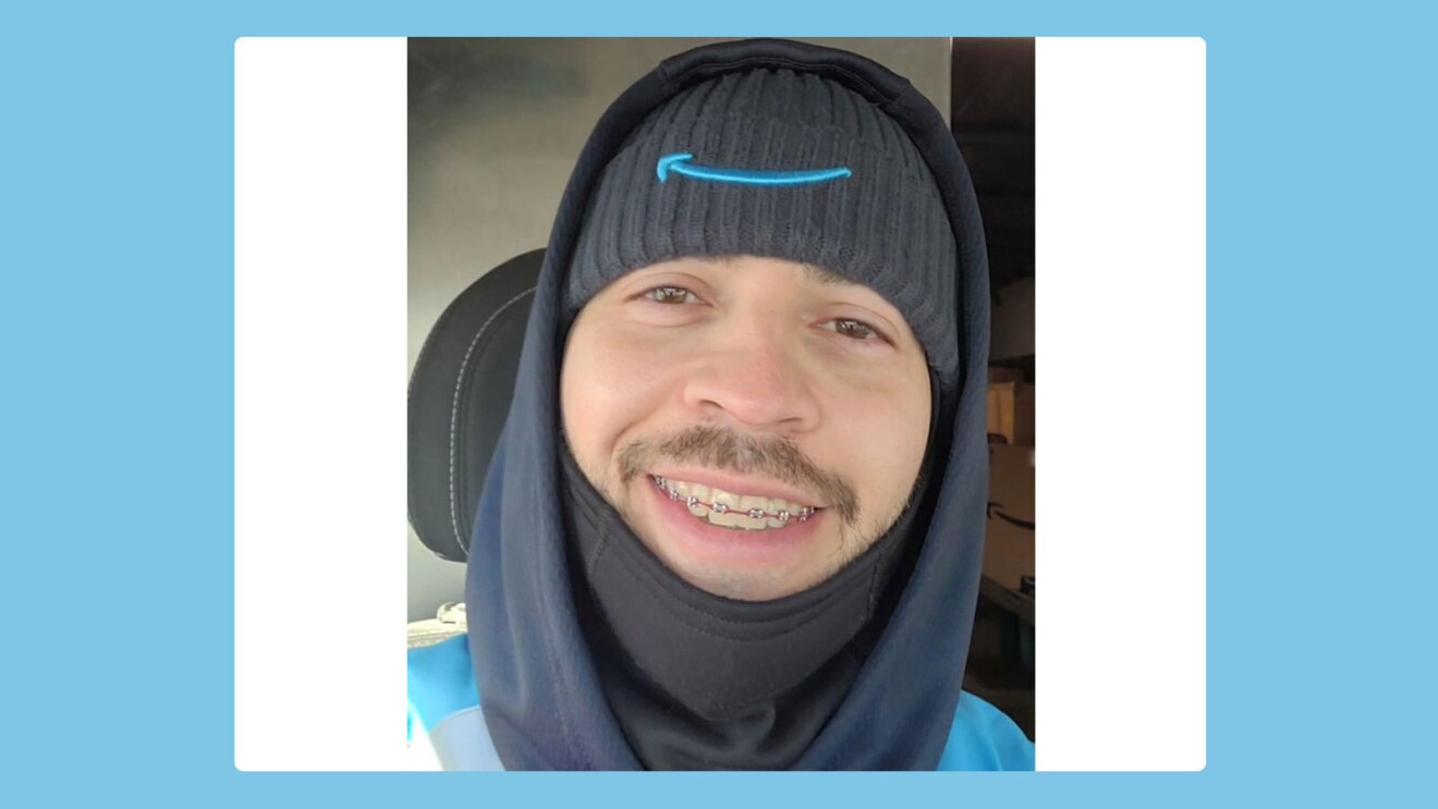 Francisco wears an Amazon smile beanie and smiles as he sits in a delivery vehicle.