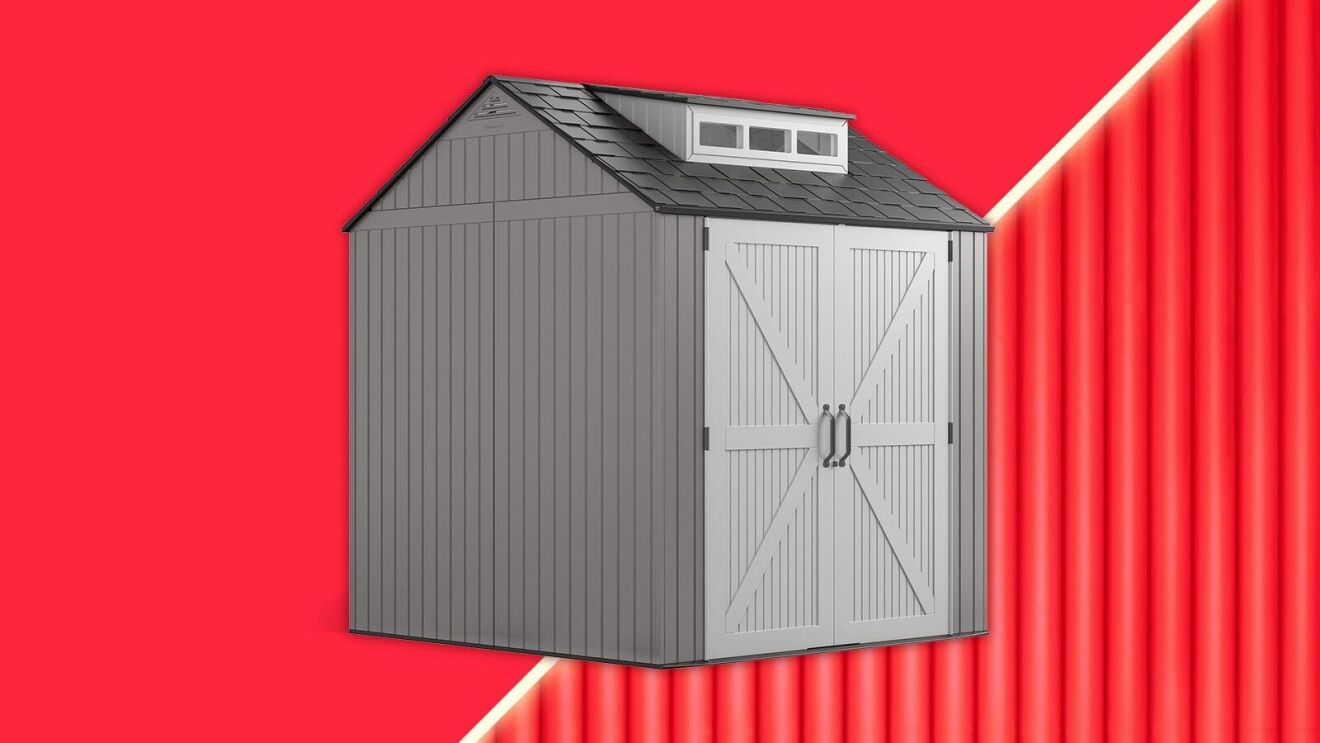 Gray storage shed with barn-style doors on vibrant red background