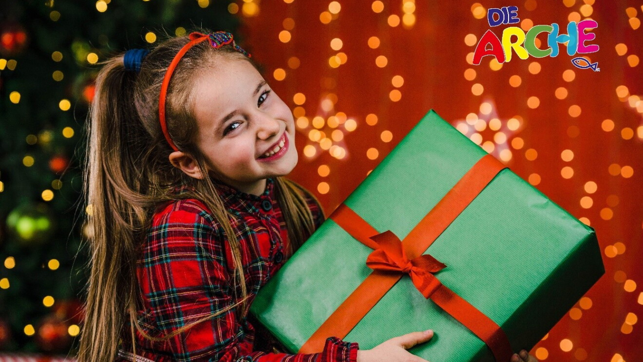 kleines Mädchen mit Weihnachtsgeschenk