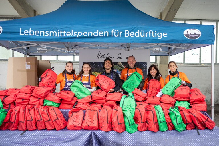Übergabe der Rucksäcke für den Schulstart an die Münchner Tafel