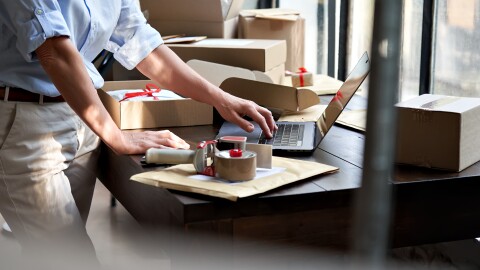 packing shipping ecommerce parcel using laptop.