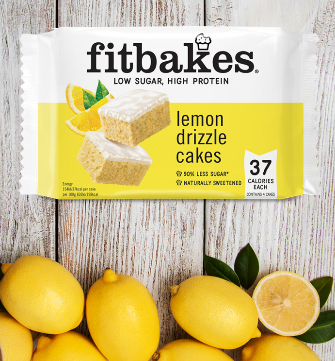 An image of a lemon flavoured Fitbakes on a wooden table with lemons at the bottom.