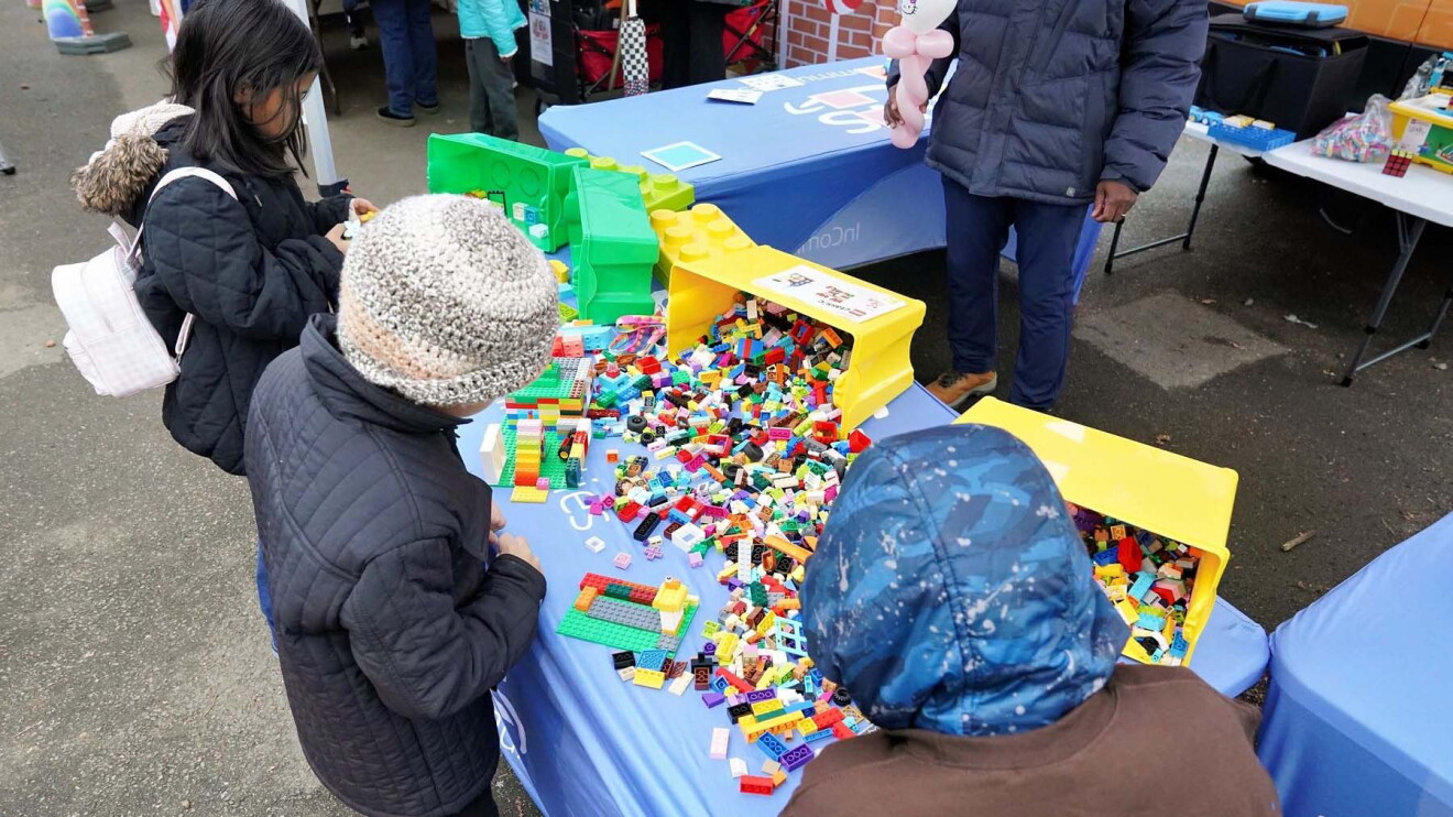 AWS in Communities: Children playing with colorful Lego bricks at outdoor event table