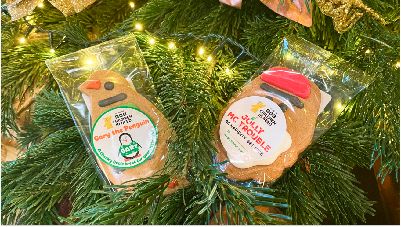 Two Children in Need Ginger Bread biscuits in their wrapping sitting in a christmas tree