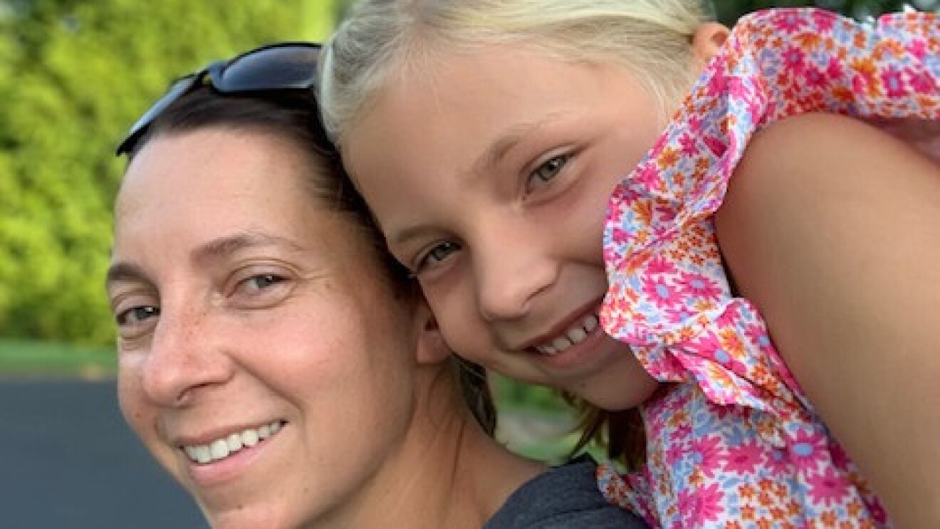 Andi and her daughter, Katelyn, pose for a picture together outside.