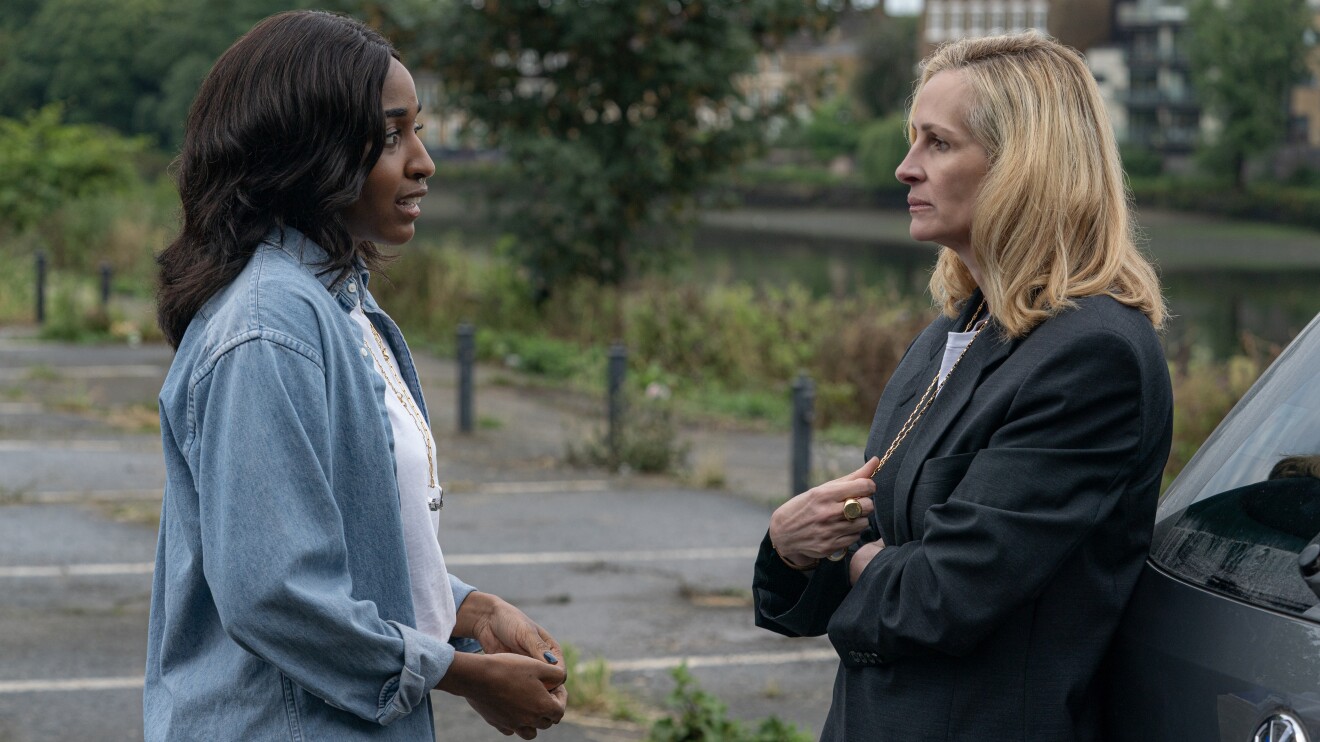Two women facing each other in serious conversation outdoors