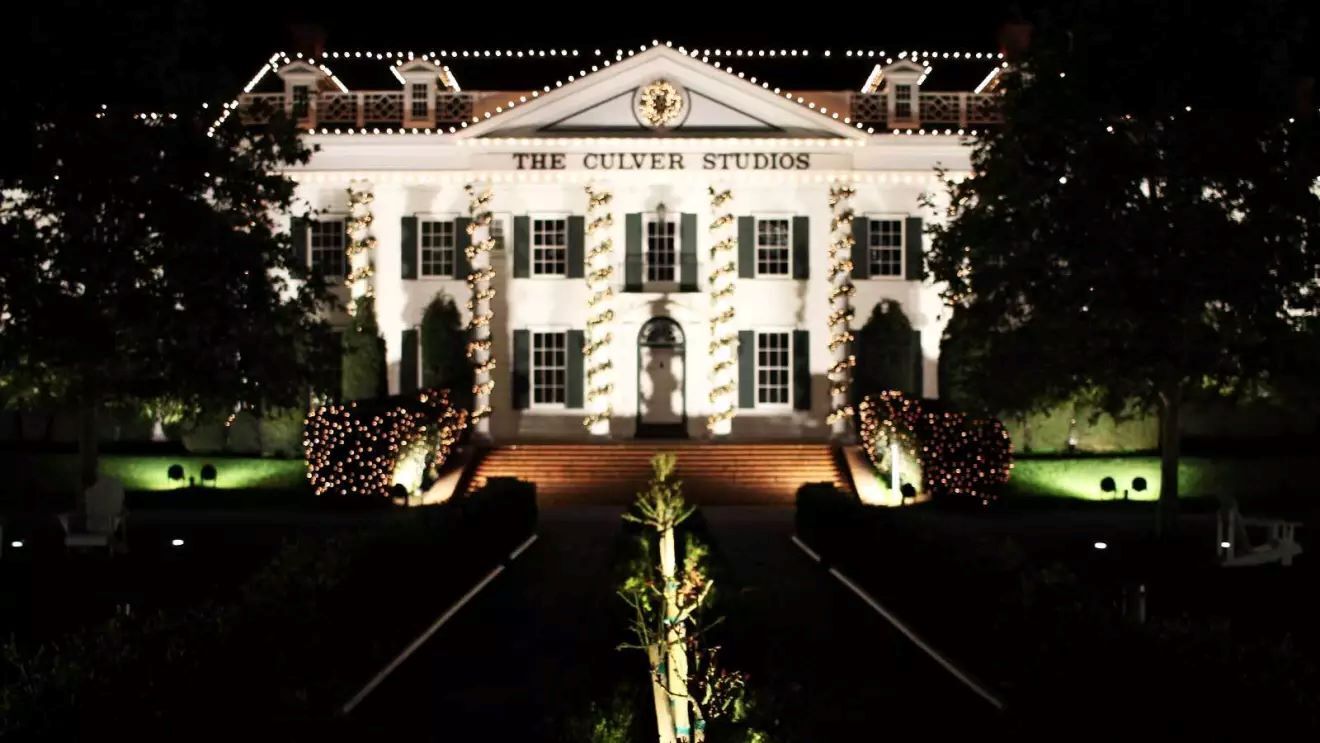 イルミネーションに彩られた白いカルバースタジオの大邸宅が夜の闇に浮かび上がって見える