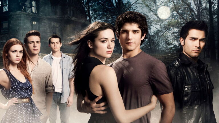 Teen Wolf cast standing in front of eerie house and woods
