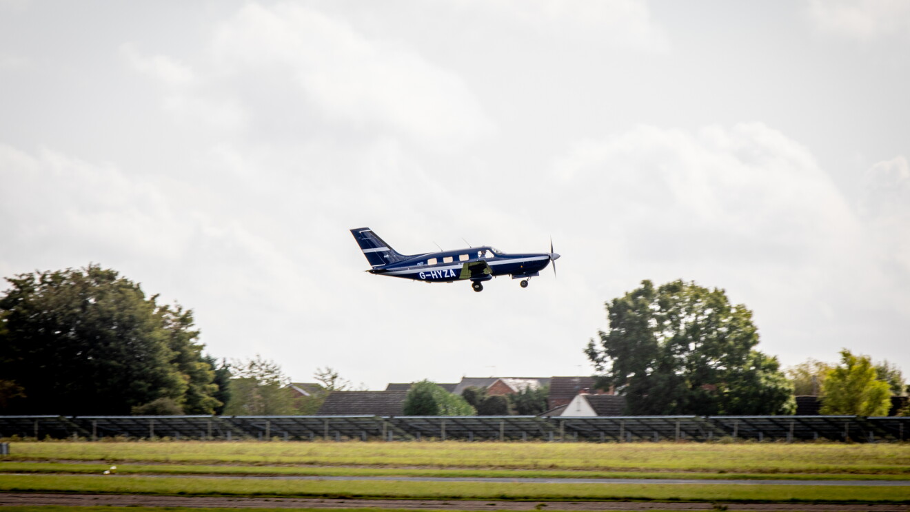 A small plane taking flight above a runway.