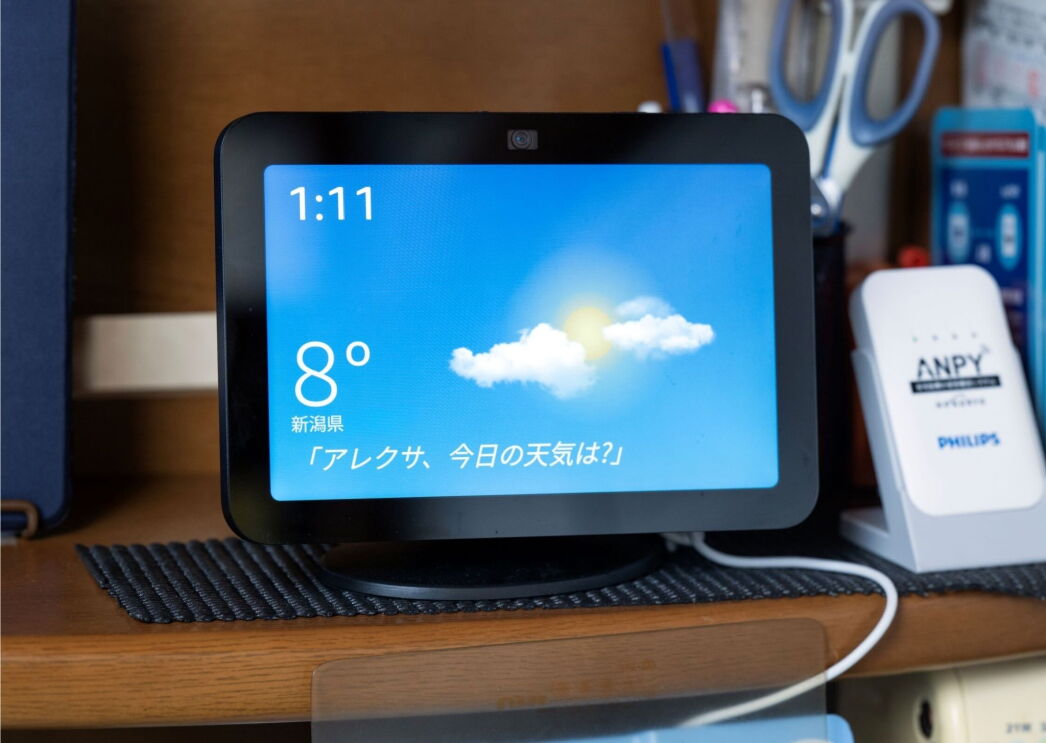 学習机に置かれているデバイス（Echo Show 8）の画面に時間と雲間から太陽が見えるイラスト、8度、新潟県の文字