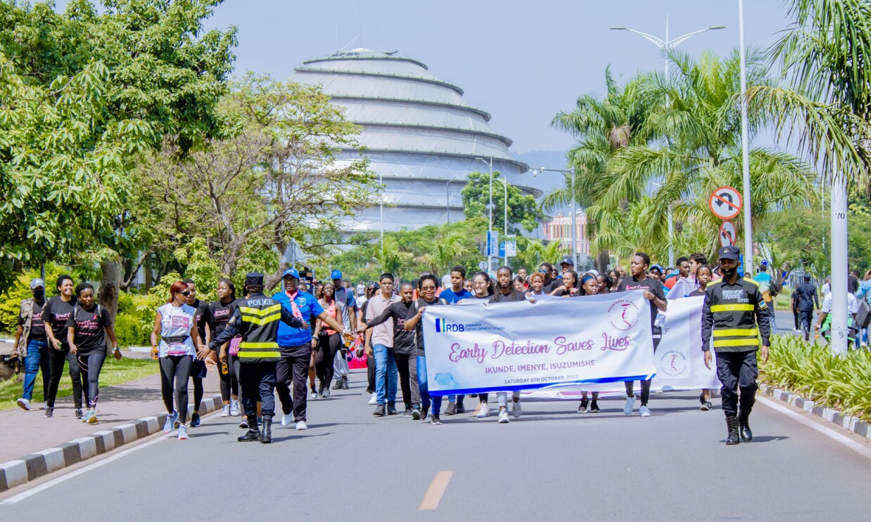 Supporters holding a promotional banner and walking for an Breast Cancer Initiative East Africa (BCIEA) cancer awareness walk.