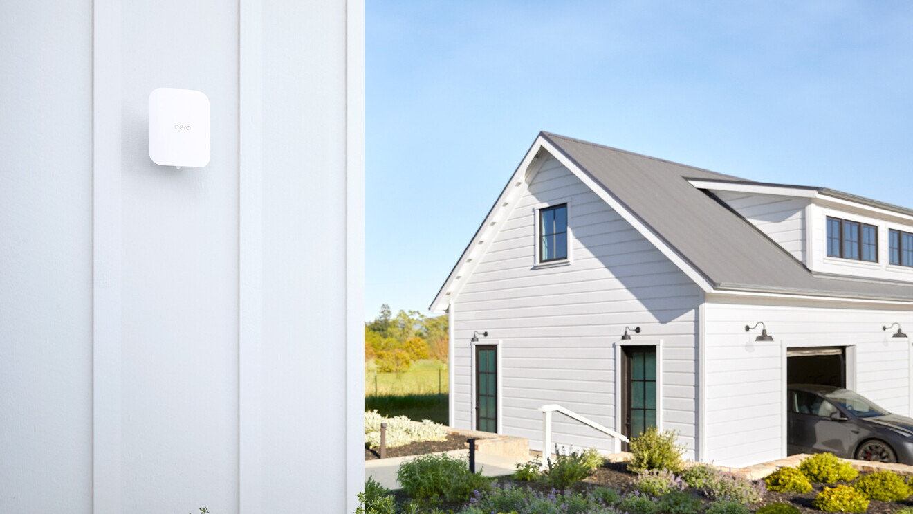White smart home eero device mounted on wall near modern farmhouse