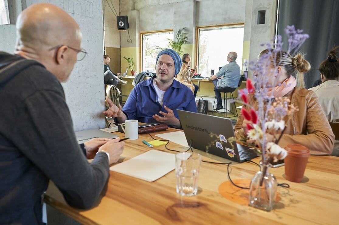 Teilnehmer bei einer Diskussion an einem Holztisch beim Amazon Sustainability Accelerator 2023