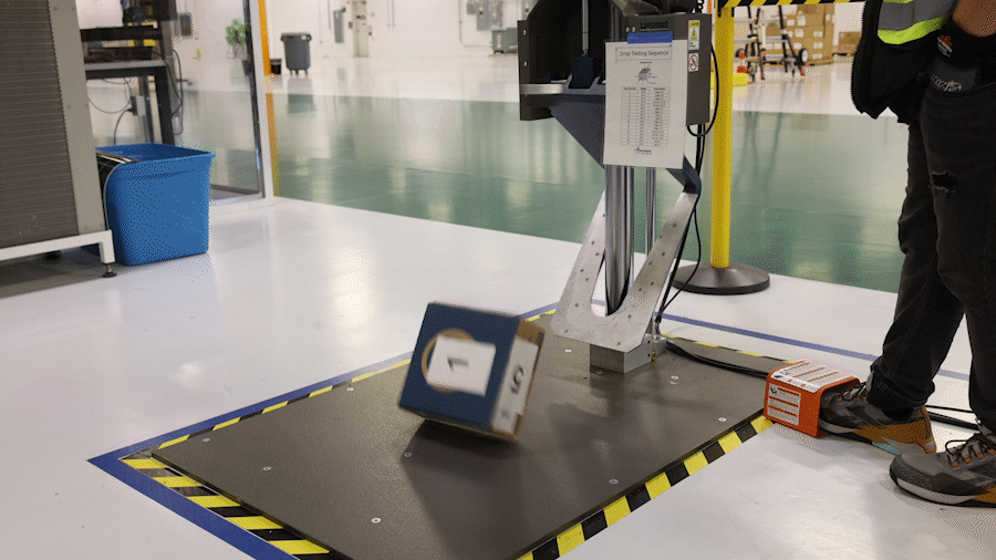 An animated GIF of a machine dropping a small box with various numbers on each side of it.