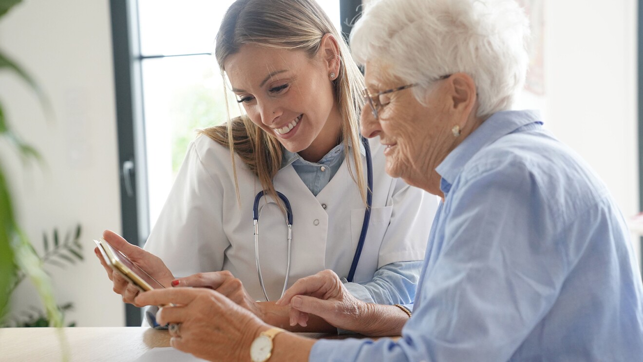 A photo and her patient looking at a tablet device.