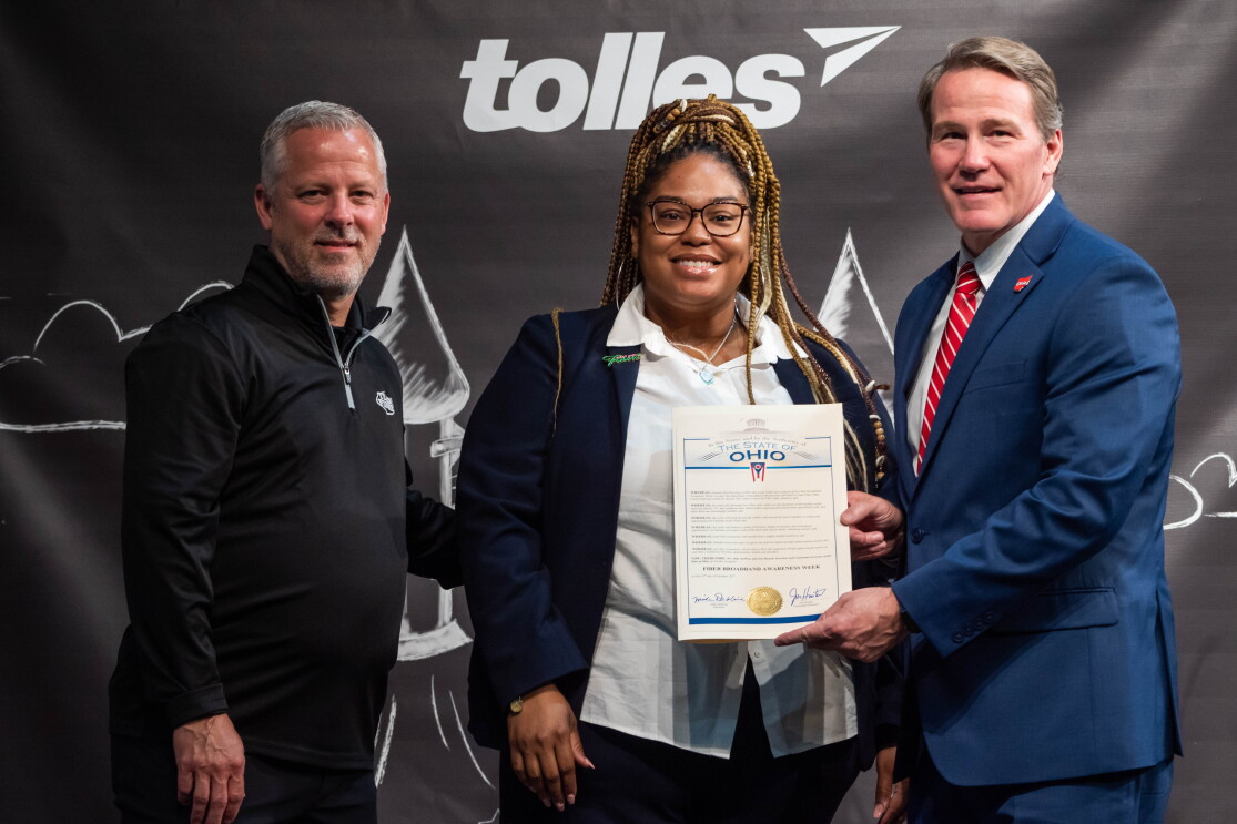 Craig Mathes, VP of Safety and Human Resources at Team Fishel, AWS Partner, standing next to two individuals presenting an award