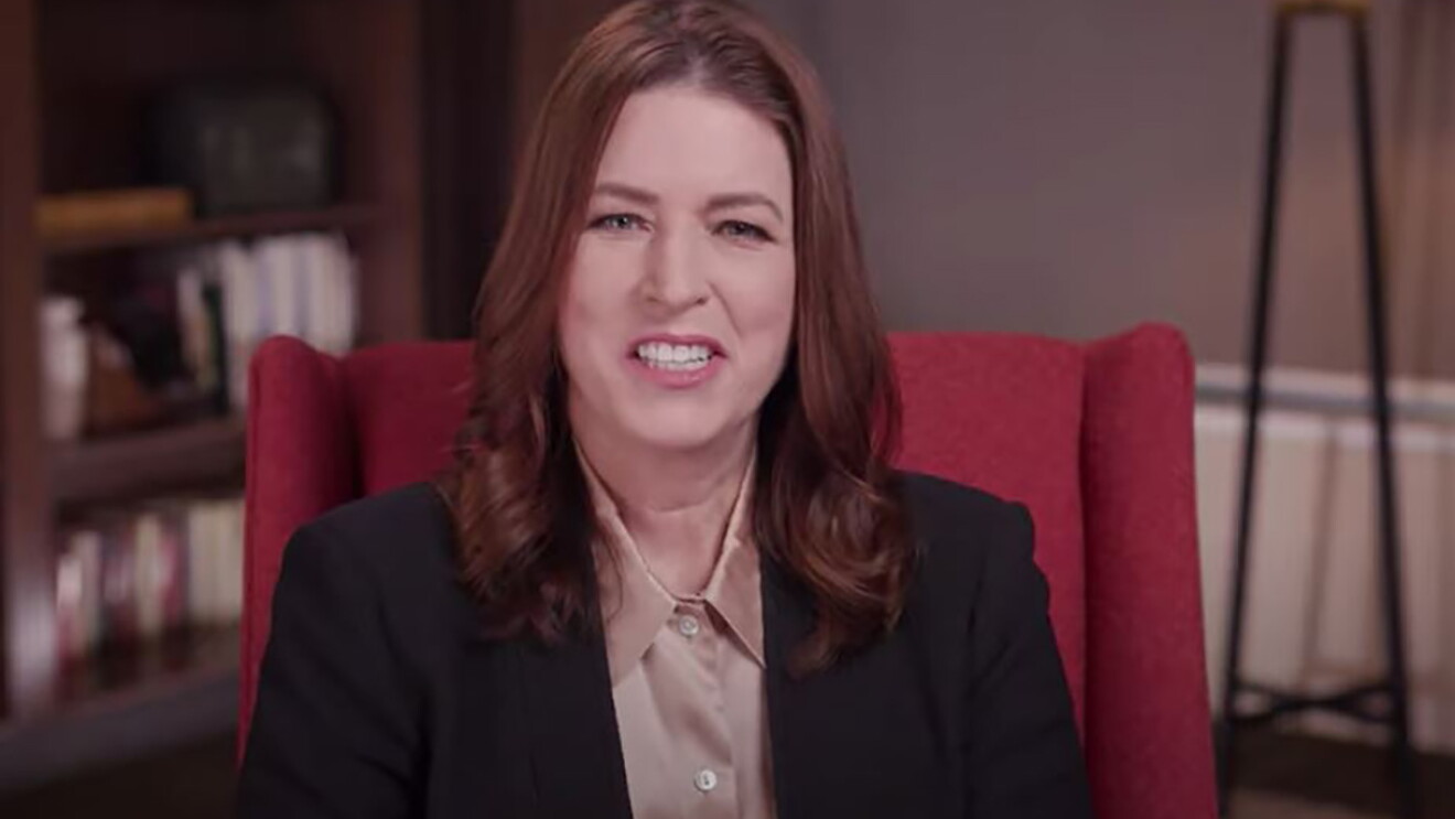 Amazon Sustainability Vice President Kara Hurst sits in an office setting in a red wingback chair. 