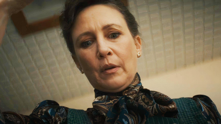 A middle-aged woman looking concerned, looking down towards the camera