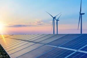 The sun sets on a wind and solar panel farm.