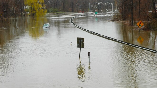 的形象被淹没的公路。有一辆货车漂浮在中间。路牌是部分覆盖在水中只有伸出来的标志。树木也在后台伸出水面。
