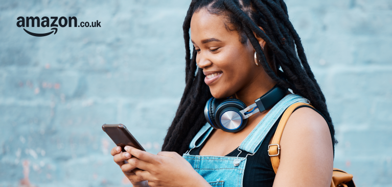 A girl smiling as she looks down on her phone