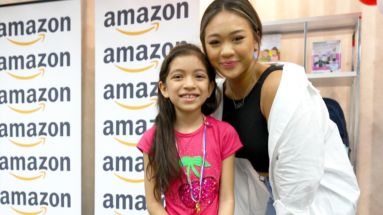 Suni Lee在一所小学与学生合影。