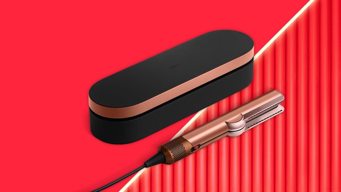 Dyson rose gold hair straightener with black carrying case on vibrant red background