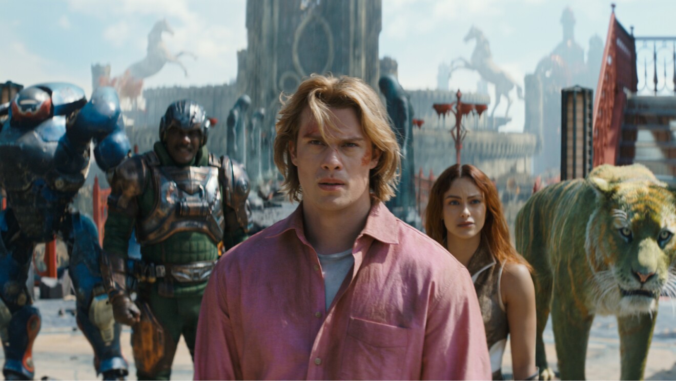 Nicholas Galitzine as He-Man with an ensemble of characters in the background.