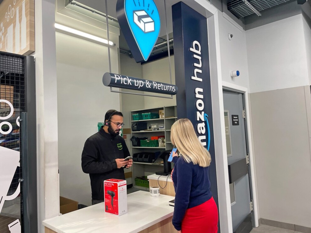 A blonde woman showing a qr code on her phone to a store associate