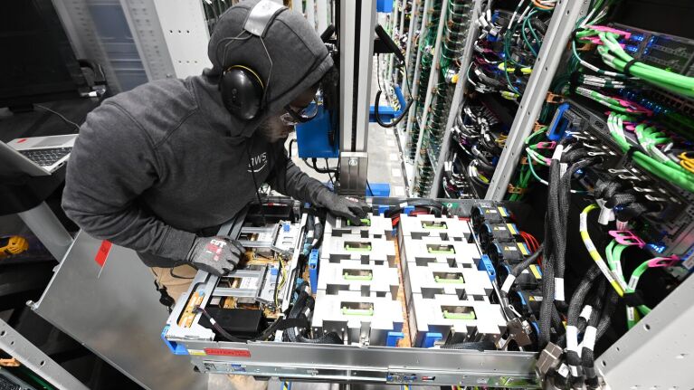 A data center technician working on a server rack.