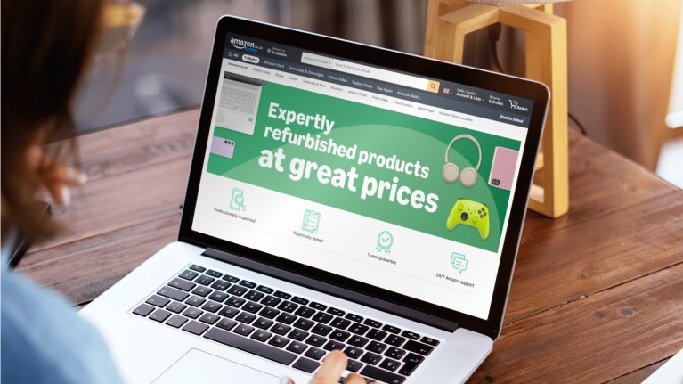 Woman on laptop with Amazon Renewed offering on screen