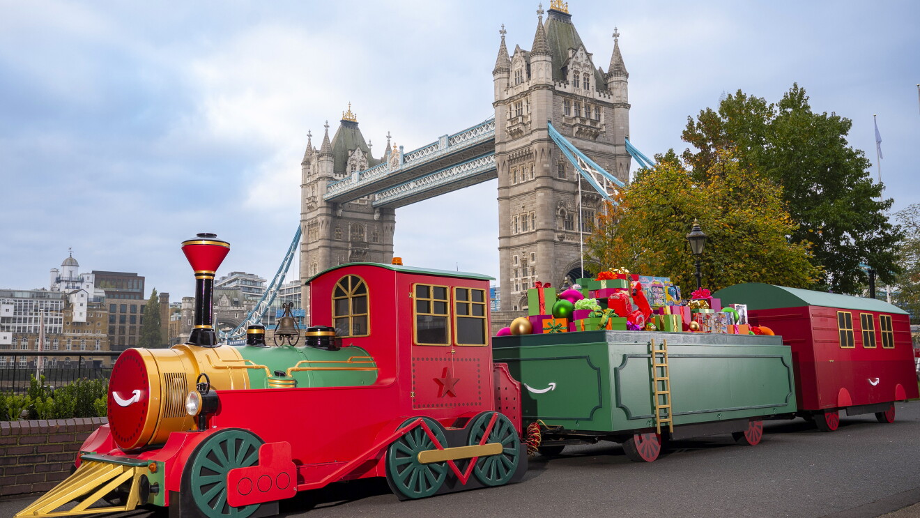 A toy train carrying toys with Tower Bridge in the background