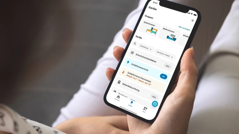 Ein Bild einer Person, die auf den Bildschirm ihres Telefons schaut das die geöffnete Alexa-App zeigt.