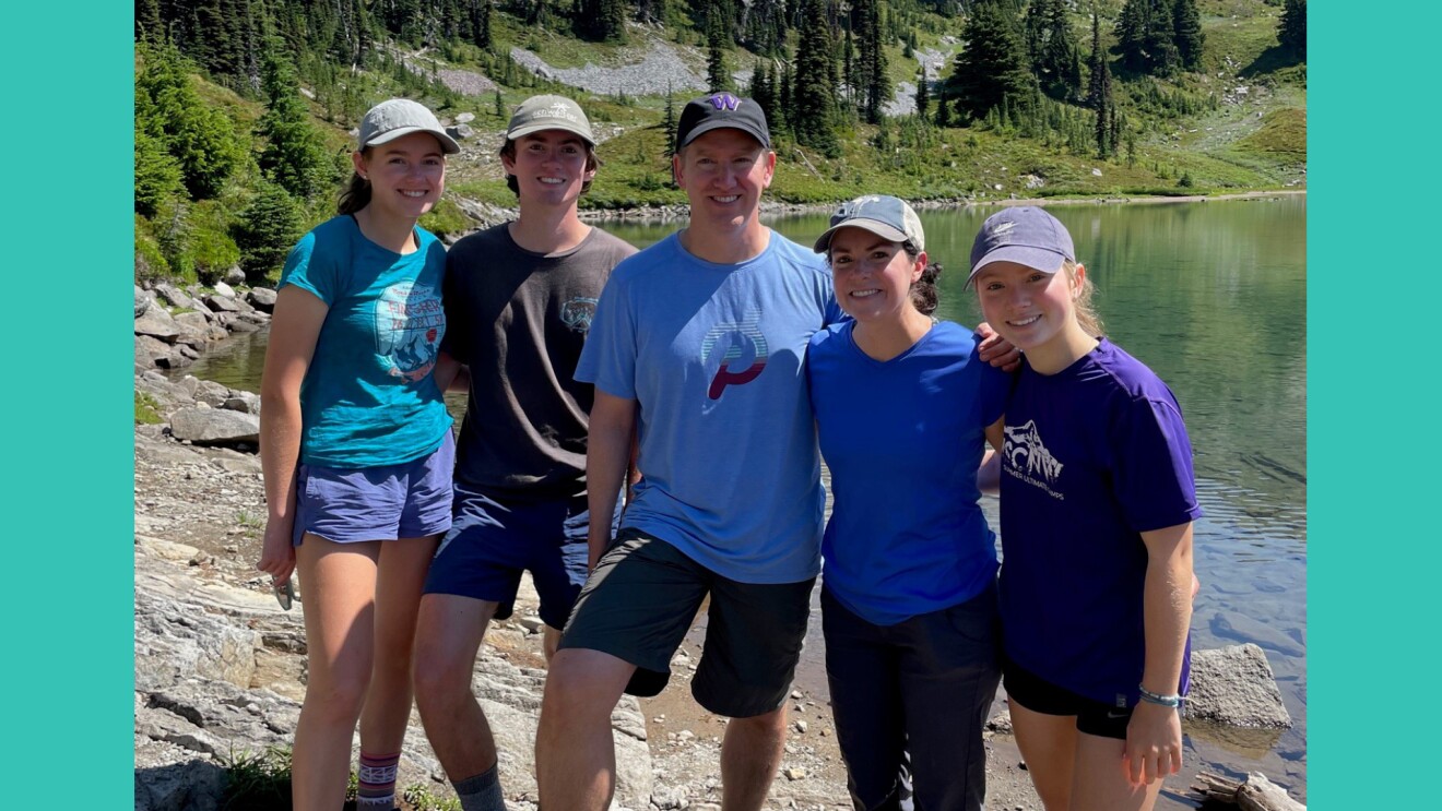 An image of a family standing by a lake on a hike.