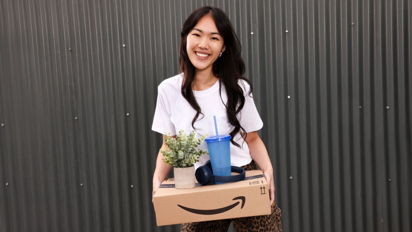 A woman holds an Amazon delivery box
