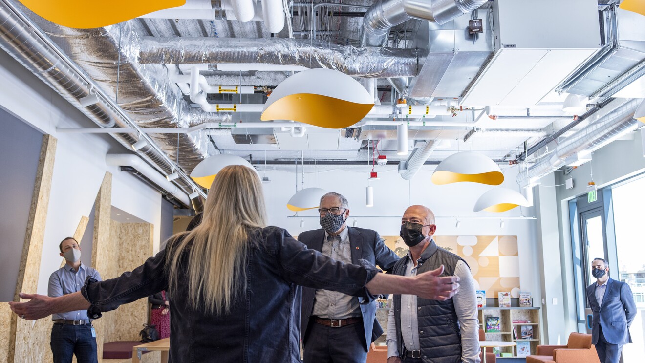 An image of the Mary's Place director greeting Gov. Inslee and Jeff Bezos as they walk into the shelter.