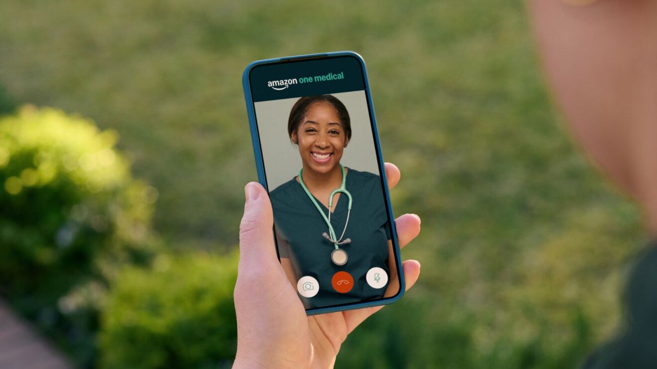 Smartphone displaying Amazon One Medical telehealth call with smiling healthcare provider