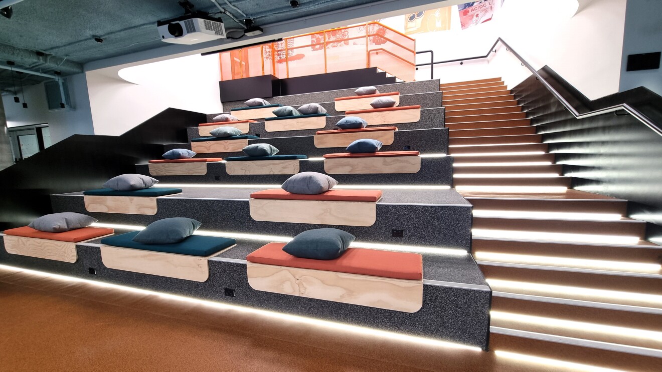 A hall with many pillows placed on the stair seats