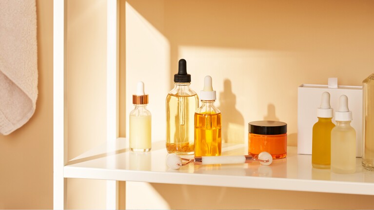 Beauty products on a shelf in a bathroom.