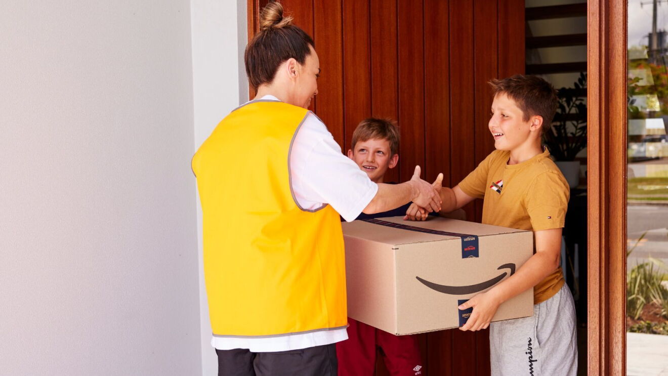 Mackenzie Arnold shaking hands with 13-year-old Antoni Harbeck and his brother Coen.
