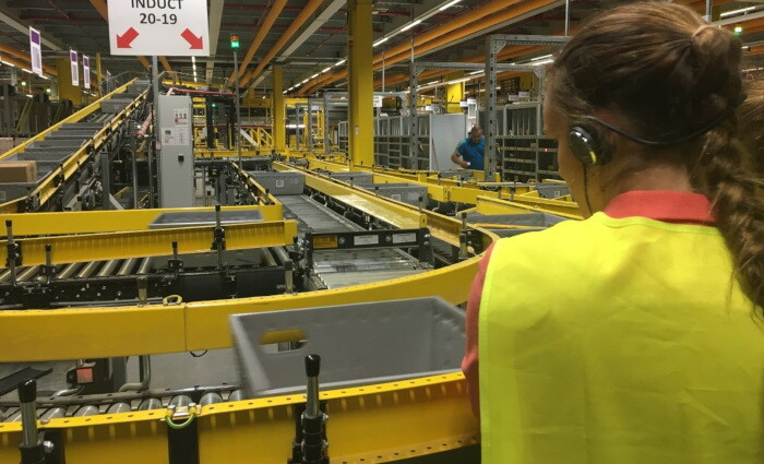 Eine Besucherin betrachtet die Förderbänder im Logistikzentrum Frankenthal