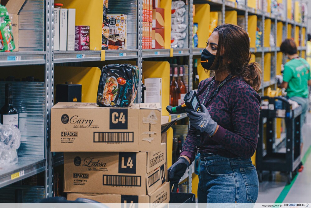 An employee scanning codes to pack products for an Amazon Fresh order